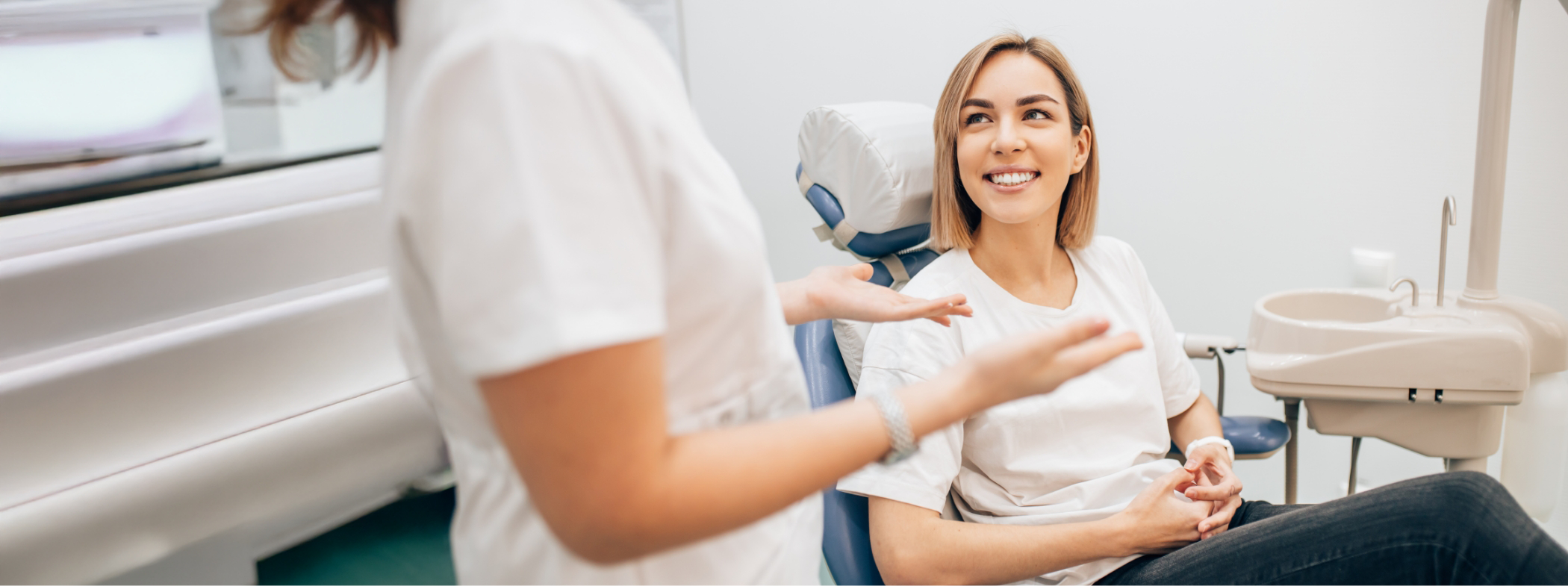 Woman in dental chair listening to her Lillington dentist talk