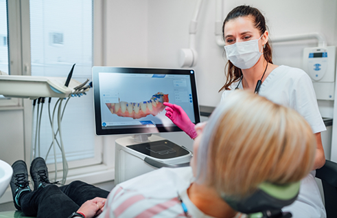 Dentist showing a patient a monitor with digital impressions of their teeth