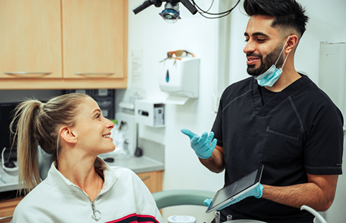 Dentist talking to a woman in the dental chair