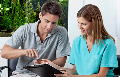 Dental team member showing a clipboard to a patient