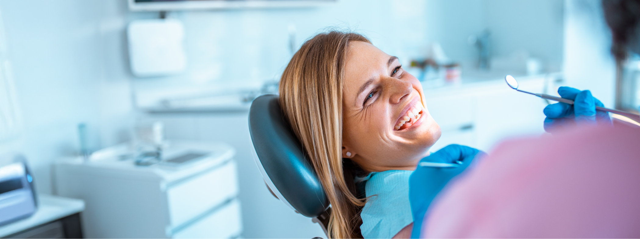 Woman grinning at her dentist during a preventive dentistry checkup