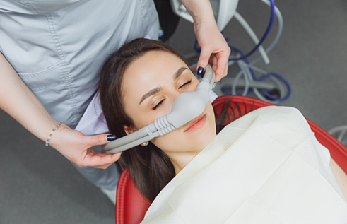 Dental patient with a nitrous oxide mask over her nose