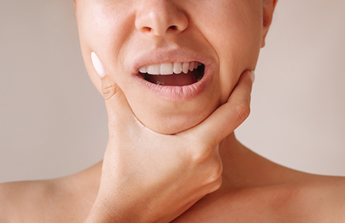 Person holding the sides of their jaws in pain