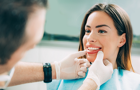 Dentist looking at a patient smiling in the dental chair